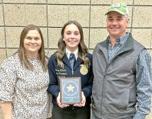 Avery Zeisler, of Gregory County FFA, stands with her parents, Ashley and John Zeisler, as she shows her proficiency award plaque.