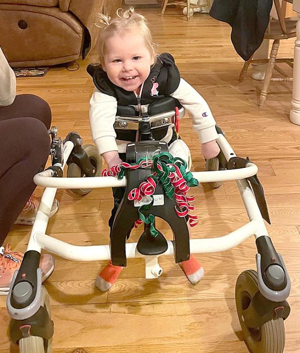 Ella gets around the house pretty well in her gait trainer, but her driving skills aren’t the best yet, as all the dents in the walls prove. (Submitted photo)